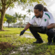 Pest control technician inspecting a fire ant mound after heavy rain in South Florida