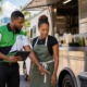 Black Caribbean In Touch Pest Control technician reviewing pest prevention with a South Florida food truck owner.